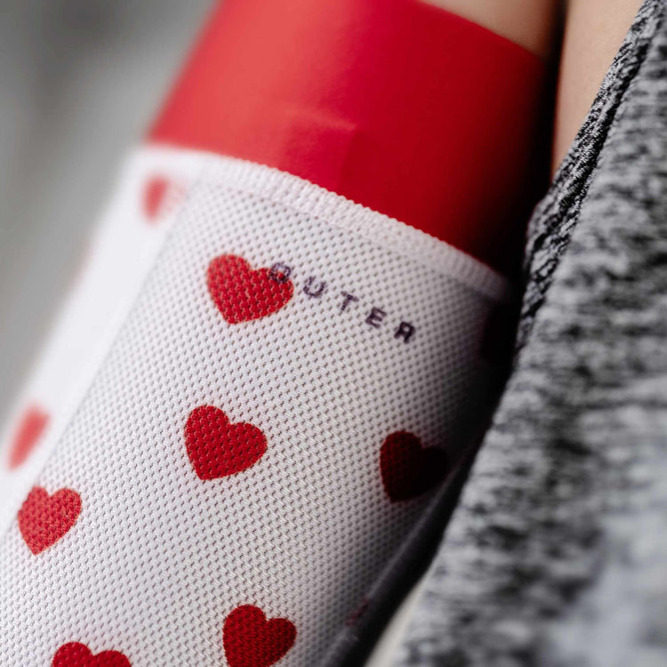 Close-up of cute heart pattern on arm sleeve, designed for track athletes and cyclists seeking style and performance.